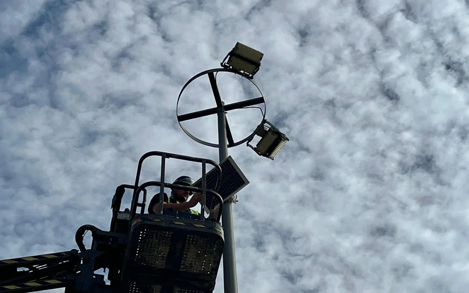 Panel solar y focos en un poste durante la instalación de una cámara