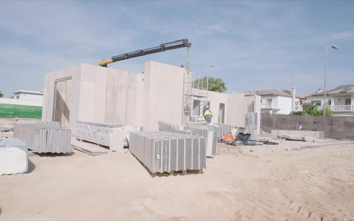 Paneles prefabricados y grúa en una obra de vivienda